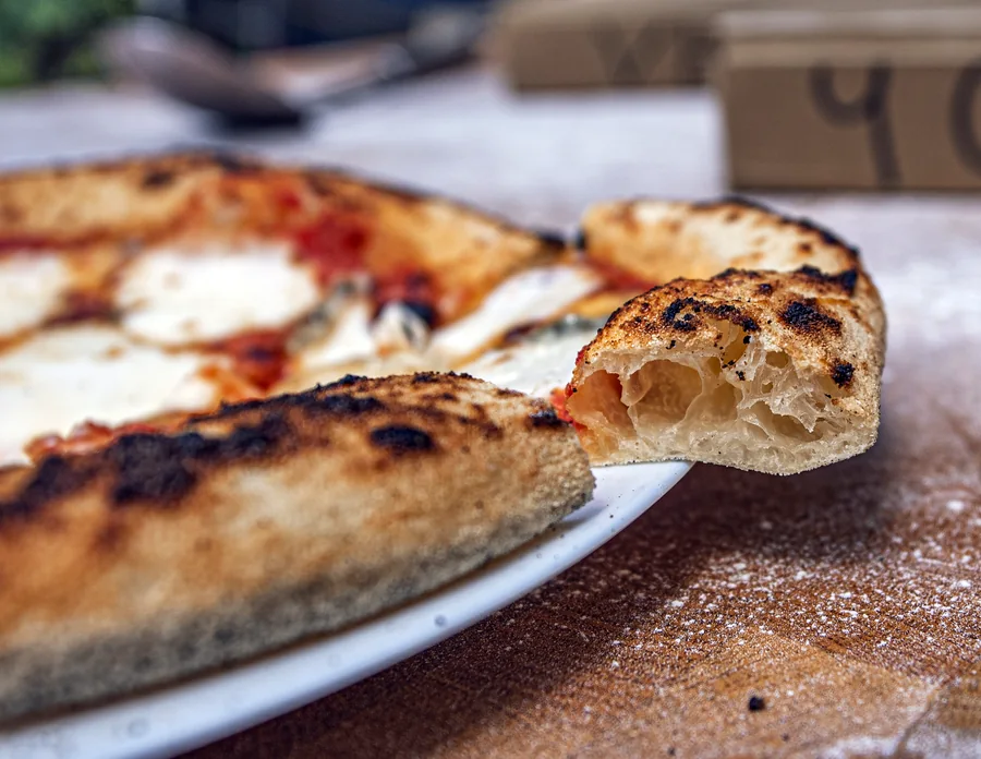 Airy Neapolitan crust, a slice pulled away